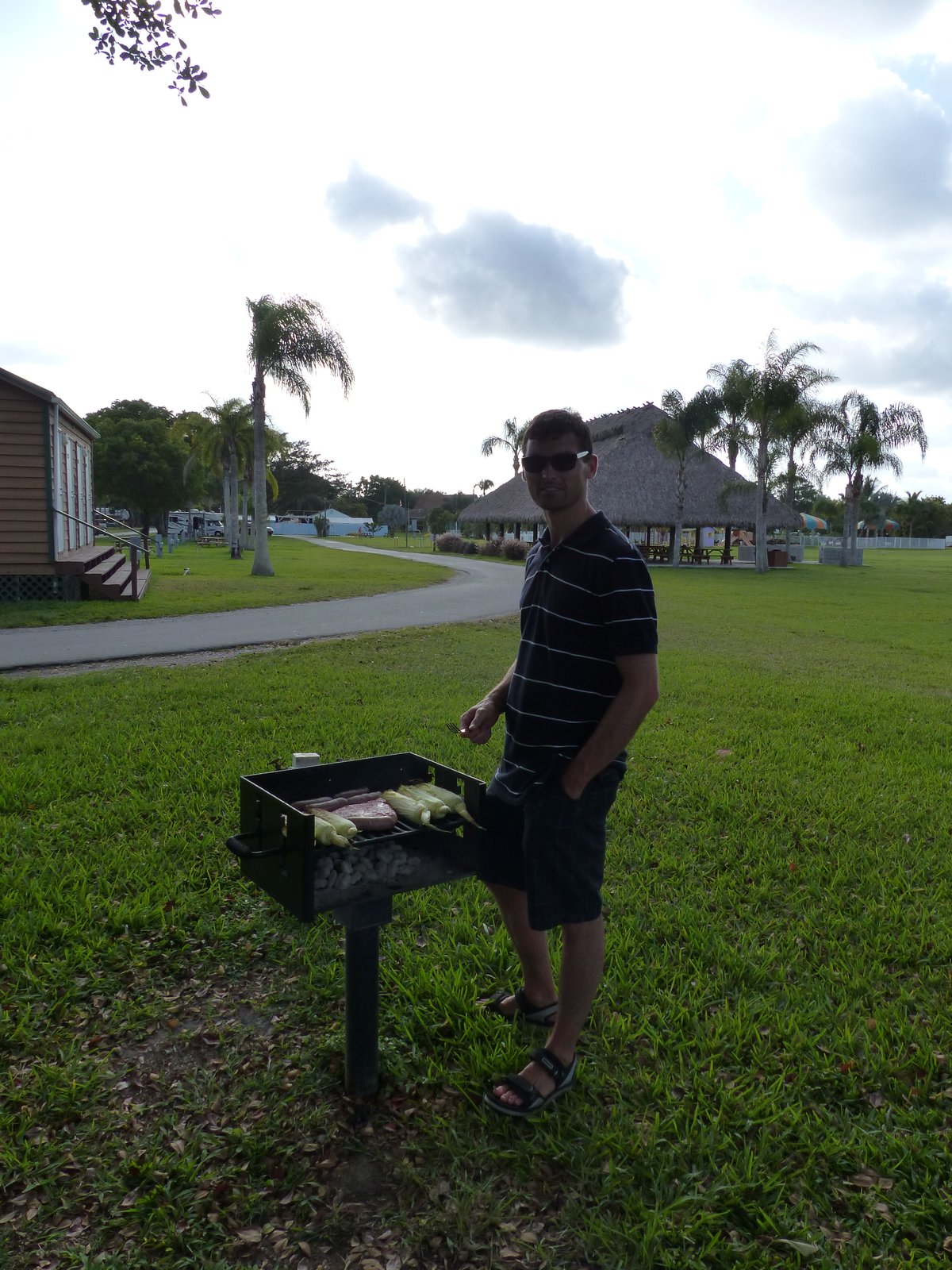 Jesper at the campground BBQ — last grill of the trip, palm trees and everything