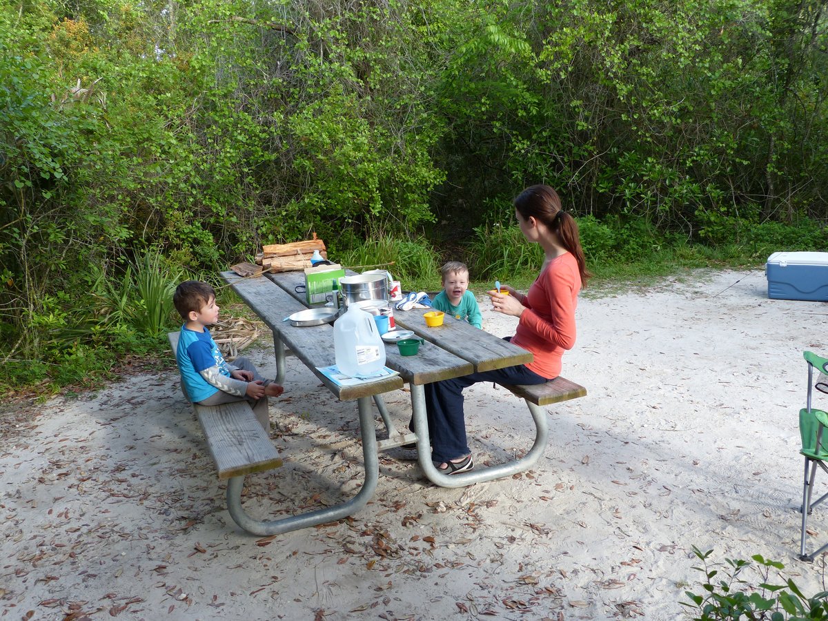 Line and the boys at the campsite picnic table — another campground morning in the Florida sun