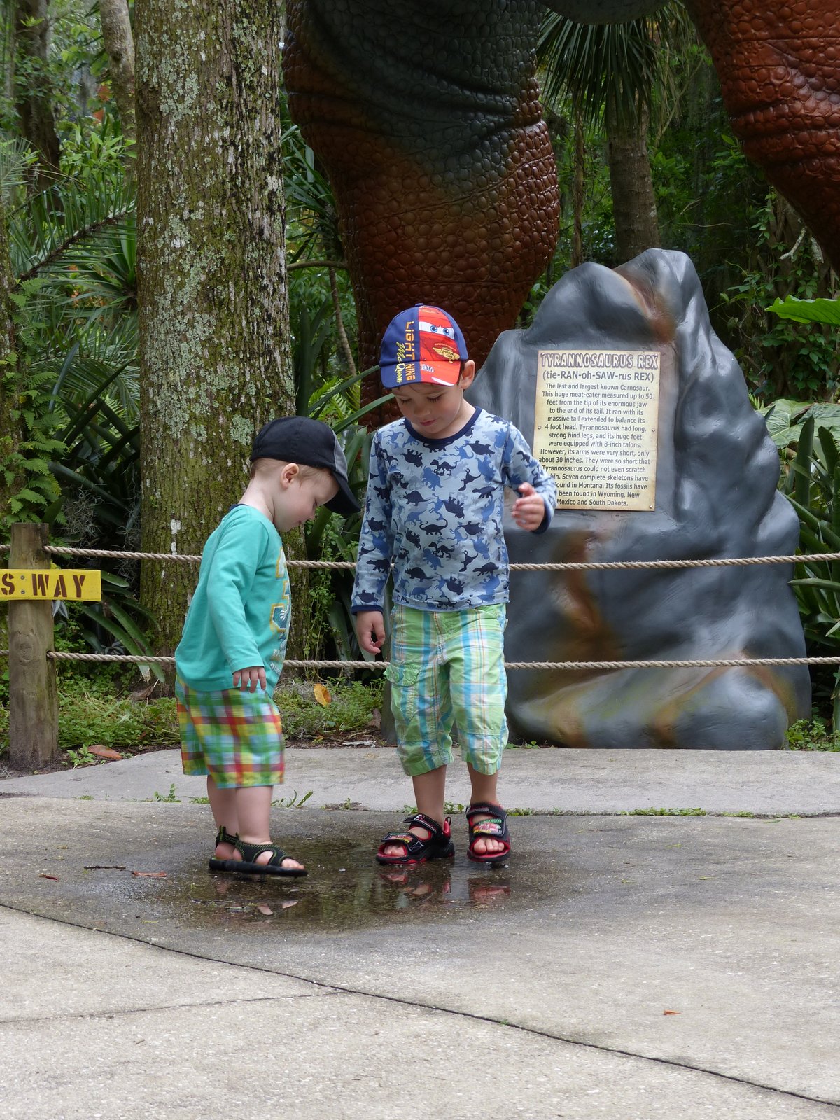 Noah and Vitus looking at a dinosaur sculpture — completely mesmerised