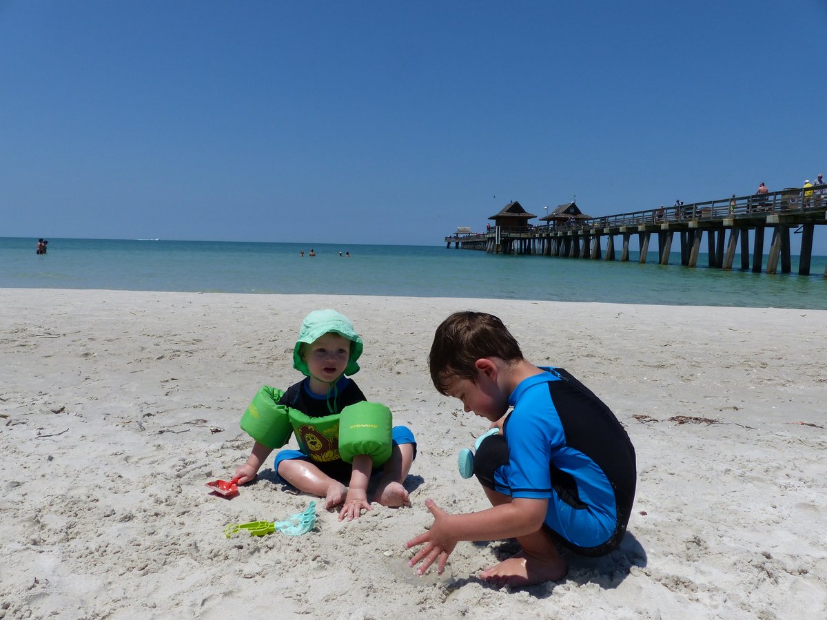 Both boys on the beach with Naples Pier in the background — the best photo of the trip