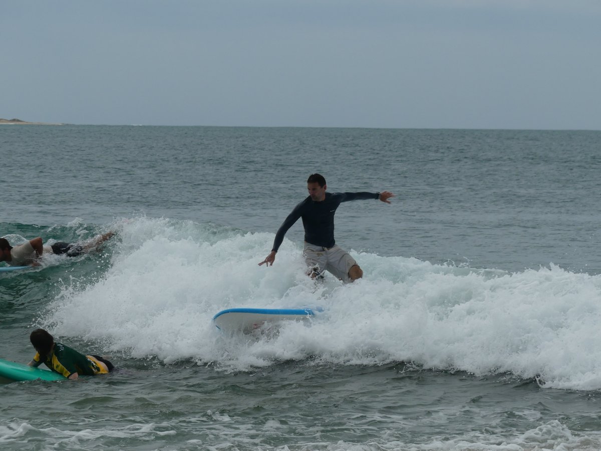 Jesper riding the whitewater with other surfers around him