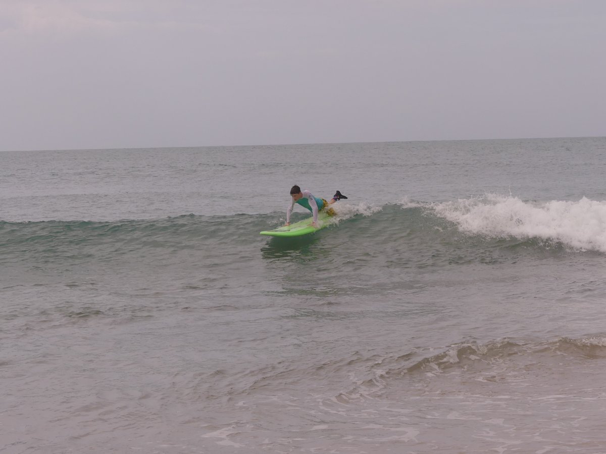 Vitus getting to his feet on the green board on a small wave