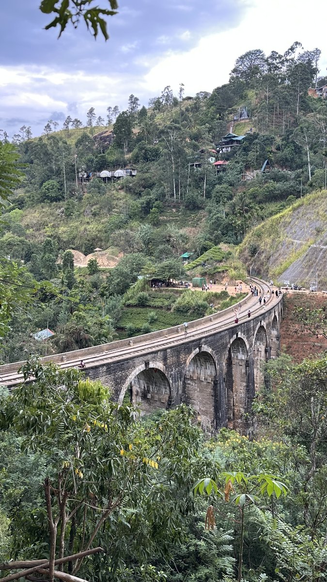The curving stone Nine Arches Bridge set into the green hillside