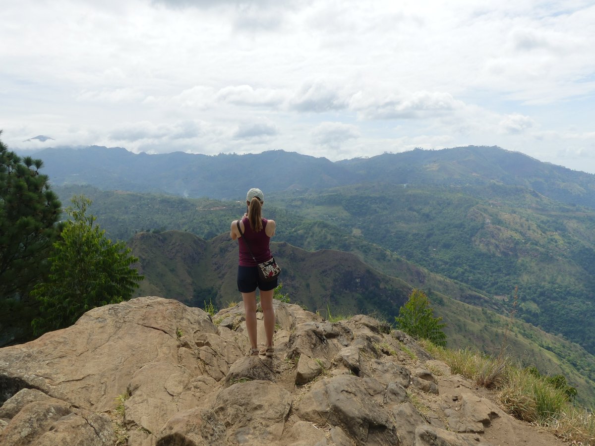 Line standing on the bare rock at the Ella Rock summit looking out over the hills
