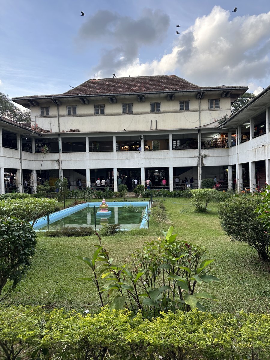 A colonial-era building with a courtyard garden and ornamental pond in Kandy