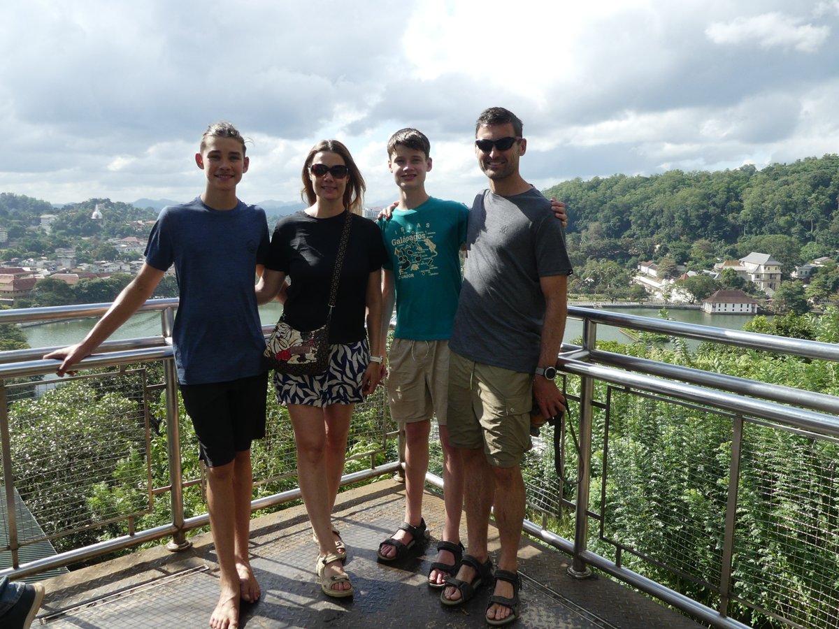 The whole family at a viewpoint above Kandy, with the lake and city in the hills behind