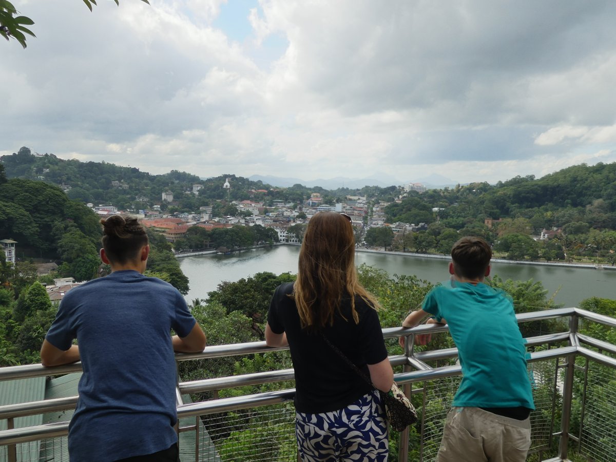 Noah, Line and Vitus at the railing looking down over Kandy Lake and the city