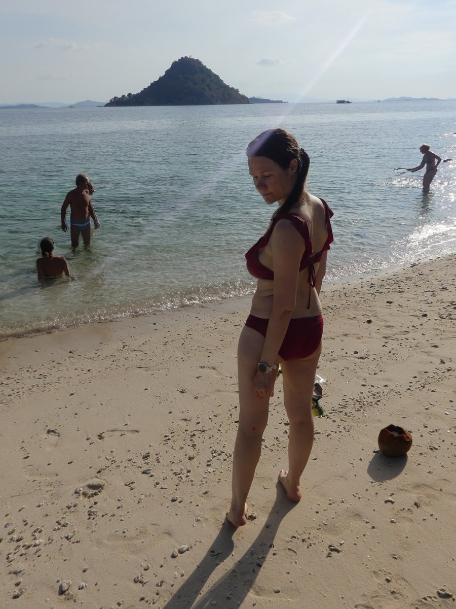 Line on the small beach below Kelor Island, a cone-shaped island offshore