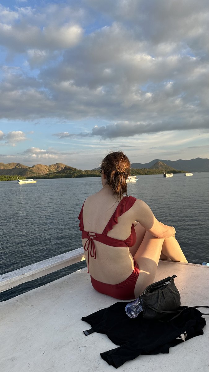 Line sitting on the boat bow watching the golden-hour archipelago