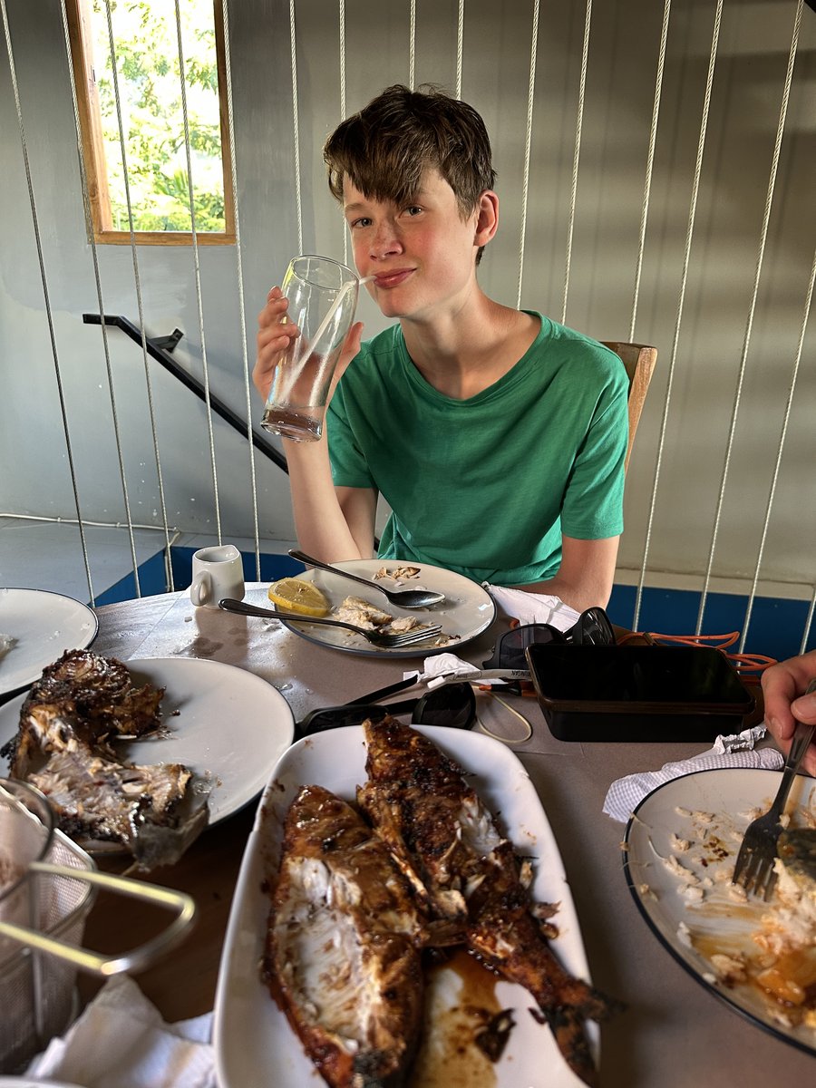 Vitus at the table with the spread of grilled fish he caught