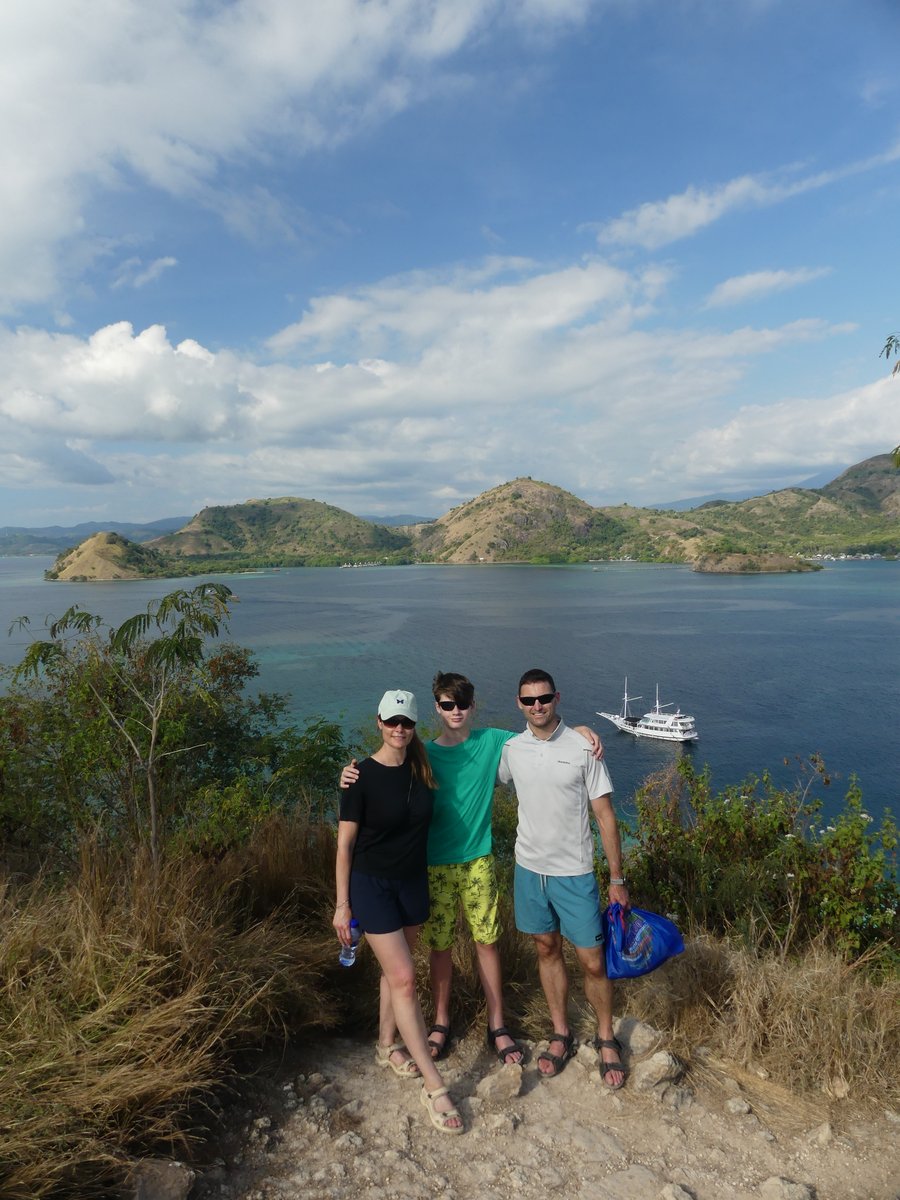 Line, Vitus and Jesper arm in arm at the Kelor viewpoint, the sunset-tour boat anchored below