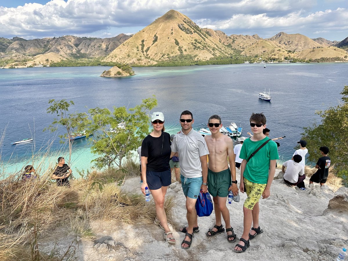 The whole family at the Kelor Island viewpoint above the turquoise lagoon and hills