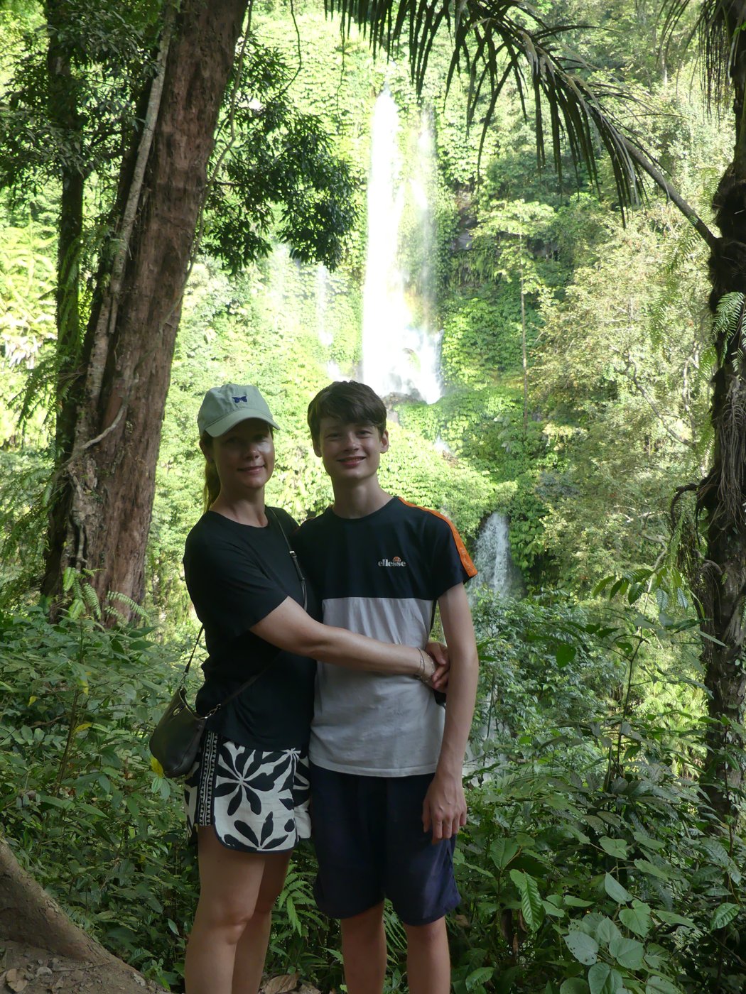 The boys among the jungle greenery by the falls