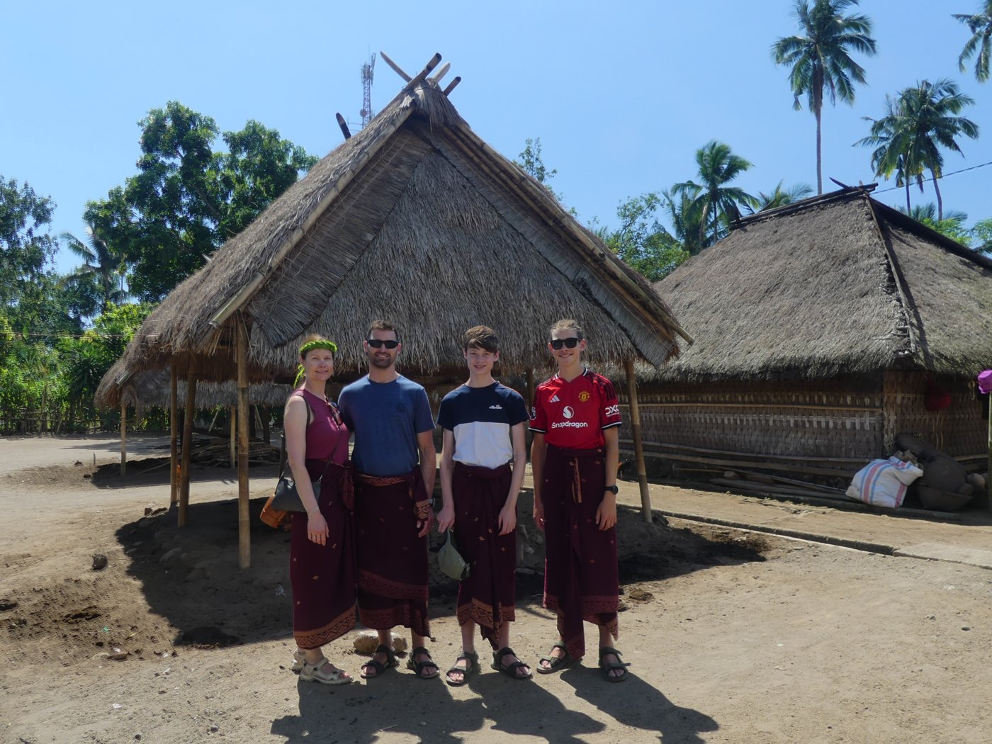 The family outside the thatched houses of the traditional Sasak village