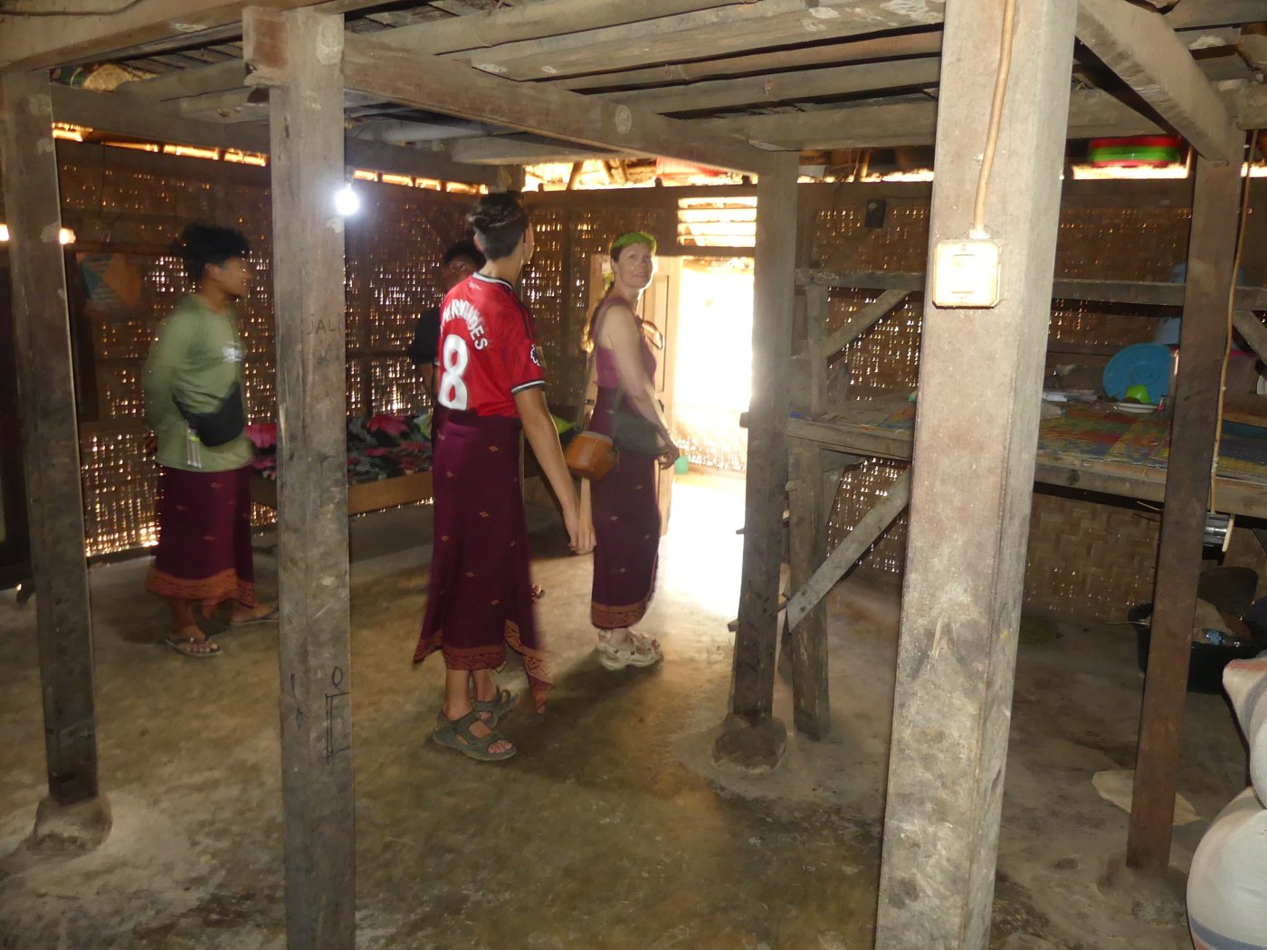 Inside a traditional Sasak house, wearing sarongs