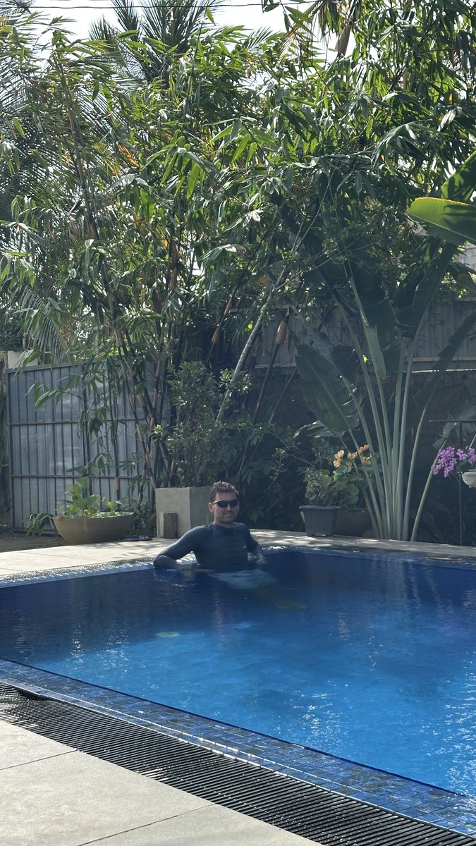Noah in the Negombo hotel pool surrounded by garden greenery