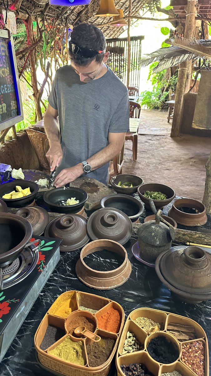 Jesper chopping at the cooking class with a spread of colourful spice trays