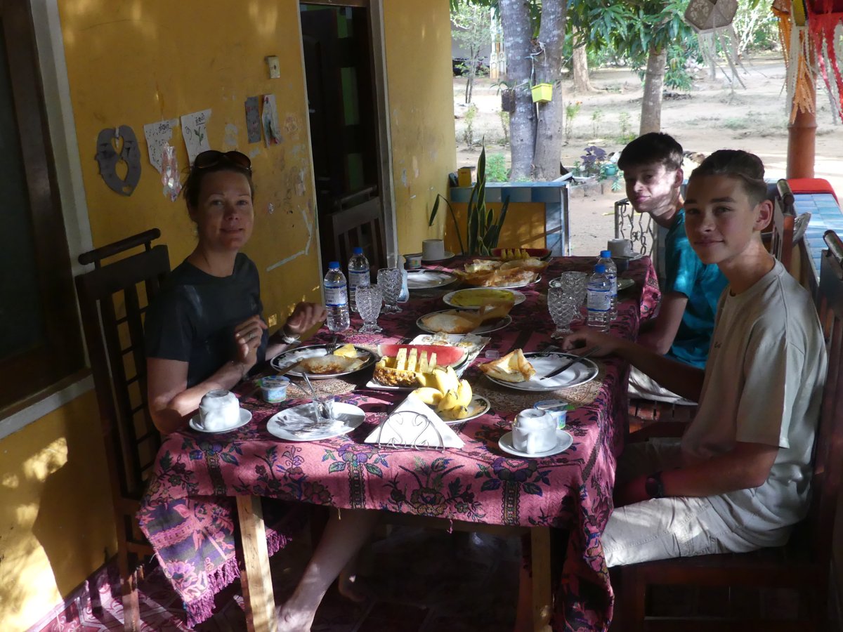 Line, Vitus and Noah at a guesthouse breakfast table spread with fruit and tea