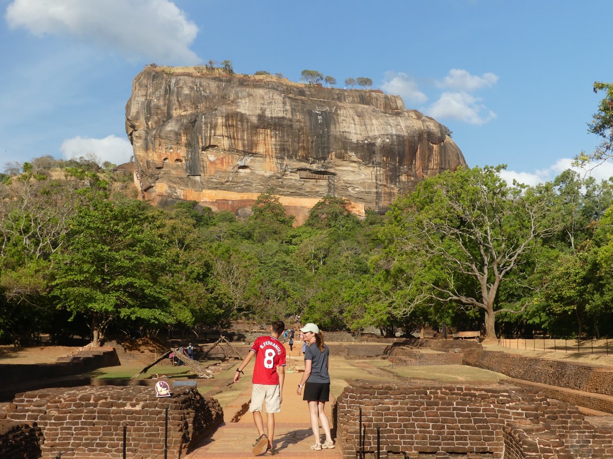 Noah and Line walking toward the towering Sigiriya rock through the water gardens
