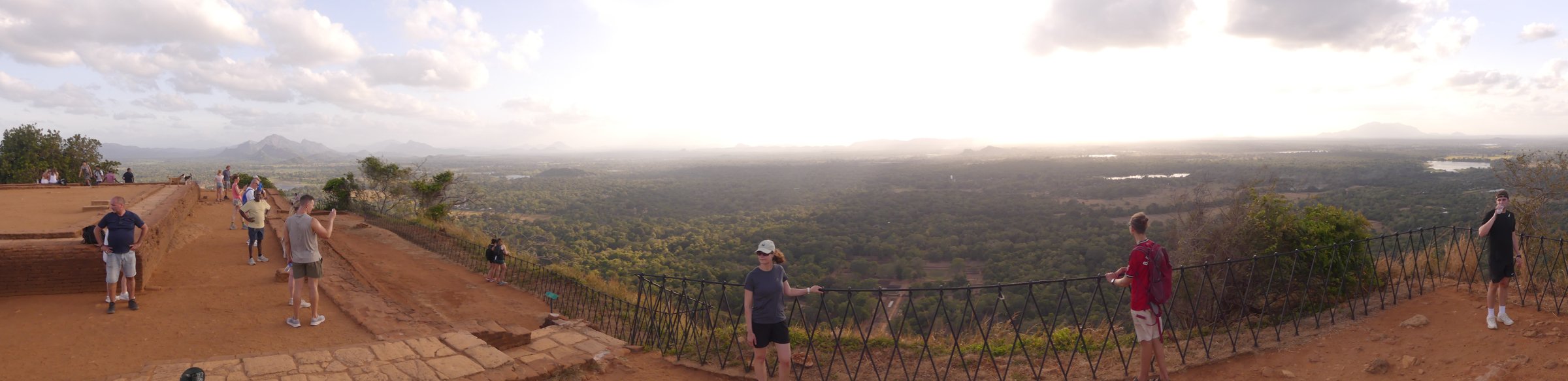 Panorama from the flat summit of Sigiriya: the brick-terraced top with visitors and the jungle plain stretching to the hills
